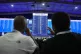 Observers look on as election results are displayed at the R