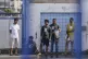 Survivors of a shipwreck stand outside a warehouse at the po
