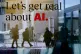 People are reflected in a window of a hotel at the Davos Pro