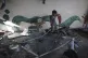 A Palestinian child navigates through heavy damage to a UNRW