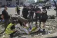 Police officers inspect a dead body after Russian attack in 