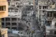 People walk past shattered buildings in Khan Younis, Gaza St