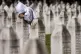 A Bosnian Muslim woman mourns next to the grave of her relat