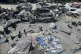 Palestinians inspect the damage at a site hit by an Israeli 