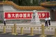 Chinese security personnel stands guard near a sign which re