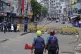 Police stand behind a barricade during an imposed curfew aft