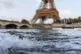 Waves crash along the banks of the Seine River in front of t