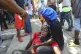 A woman is affected by tear gas fired by police to disperse 