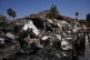 A man works next to a destroyed home after rockets struck in