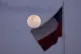 A Chilean national flag waves as the moon rises in Santiago,