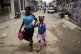 A child sips on a drink as she is walked home from school, i