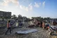 Palestinians look at the destruction after an Israeli airstr