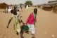 Sudanese refugee girls carry water supplies near a polling s