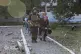 An elderly woman is assisted by emergency services personnel