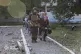 An elderly woman is assisted by emergency services personnel