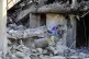 A boy checks the damage to a building hit in an Israeli airs