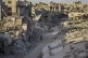 Palestinians walk through the destruction left by the Israel