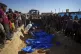 People bury the bodies of Palestinians taken by the Israeli 