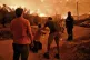 A resident reacts as a wildfire approaches the village of An