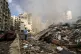 A man documents the damaged buildings at the site of an Isra