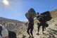 People carry their luggage as they cross on foot into Syria 