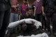 A Palestinian man holds the body of a relative killed in the