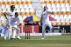 England's Chris Woakes (right) bowls as Joe Root (left front