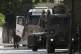 An Israeli soldier stands by a bulldozer and vehicles during