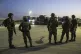 Israeli soldiers stand near trucks carrying humanitarian aid