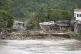 Debris from damages are gathered along a bridge after floods