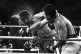 Perspiration flies from the head of George Foreman as he tak