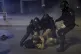 Police hold a seasonal firefighter outside Greece's Civil Pr