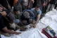Palestinians mourn their relatives killed in the Israeli bom