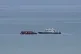 A boat thought to carry migrants is escorted by a vessel fro