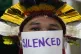 An activist participates in a demonstration with the word si