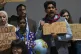 A demonstrators holds a sign that reads ‘don't burn our fu