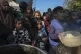 Palestinian children queue at a food distribution kitchen in