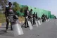 Paramilitary soldiers stand guard with riot gears at a road 