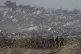 Israeli soldiers look at a destroyed part of Gaza City from 