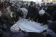 Palestinians carry the body of victim of an overnight Israel