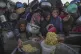 Palestinian girls struggle as they get donated food at a dis
