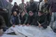 Palestinians mourn over victims during their funeral after a