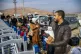 A Syrian holds his cat as he waits with others to cross into