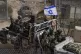 Israeli soldiers with the national flag stand on an armoured