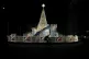 A man rides a bicycle past Christmas decorations on a street