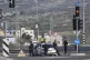 Israeli policemen block a main road after gunmen opened fire
