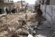 Palestinians gather on and next to a street damaged in an Is