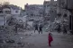 Palestinian children play next to buildings destroyed by Isr
