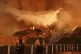 Firefighters watch as water is dropped on the Palisades Fire