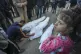 A girl watches as Mohammad Eid mourns his cousin Dima, along